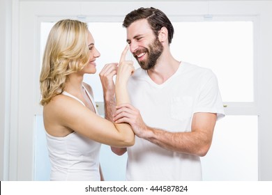 Woman Applying Cream To Her Man In Bathroom