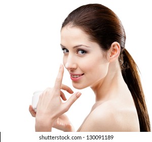 Woman applying cream from white container on her nose, isolated on white