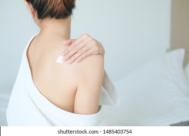 The Woman Is Applying Cream,lotion On Her Back., Hygiene Skin Body Care Concept.