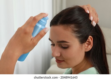 Woman Applying Dry Shampoo Onto Her Hair At Home