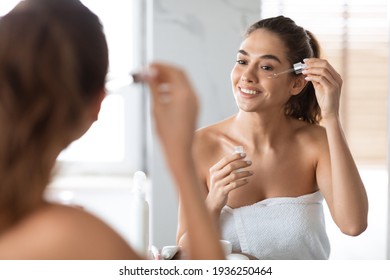 Woman Applying Face Serum Using Dropper Caring For Skin Indoors - Powered by Shutterstock