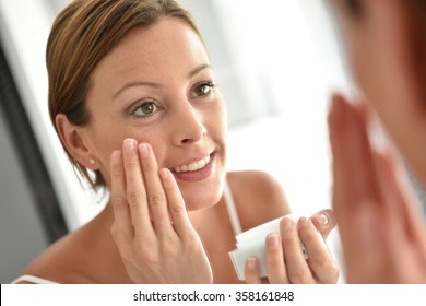 Woman Applying Facial Cream On Her Face