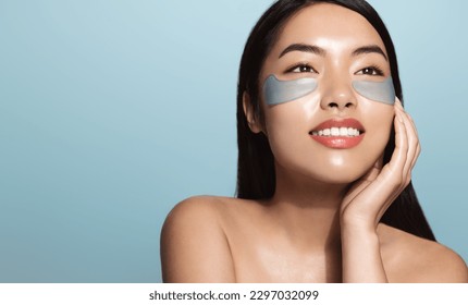 Woman applying golden eye patches. Close up portrait girl. Young woman applying collagen patches under eyes, taking care of delicate skin around eyes. - Powered by Shutterstock