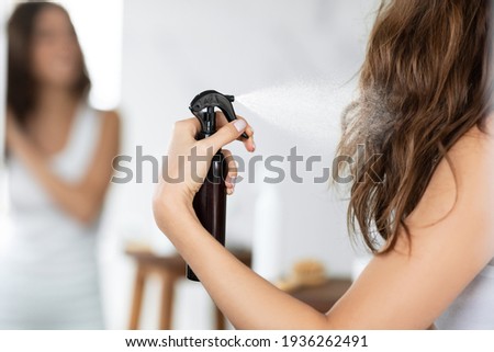 Woman Applying Hairspray Styling Wavy Hair In Bathroom Indoors, Cropped