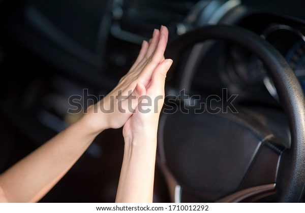 woman is\
applying hands sanitizer on her hands in\
car