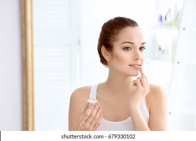 Woman Applying Hygienic Lip Balm In Light Room