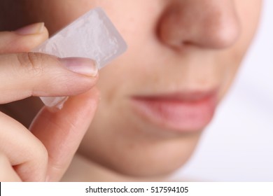 Woman Applying Ice Cube To Refresh Her Face Skin Near Eyes. Beauty, Skin Care Concept