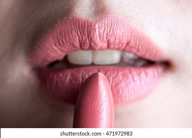 Woman applying lipstick nude color on chapped lips - closeup - Shutterstock ID 471972983