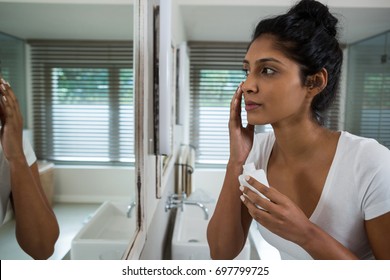 Woman Applying Lotion In Bathroom At Home