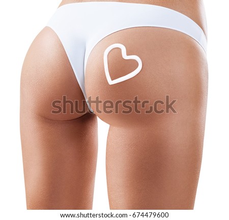 Woman applying moisturizer cream on buttocks. Anti-cellulite concept.