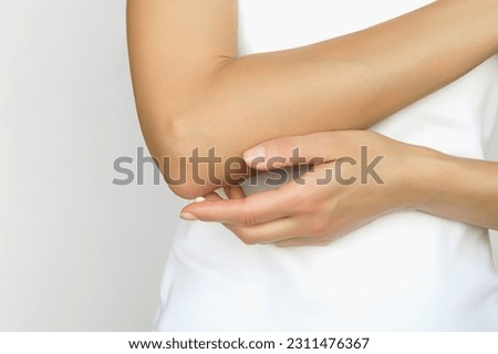 woman applying moisturizer on elbow skin, care for dry elbow skin