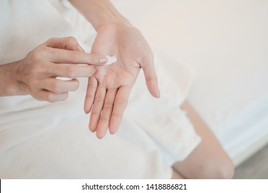 Woman applying moisturizing cream/lotion on hands, Top View, beauty concept. - Shutterstock ID 1418886821