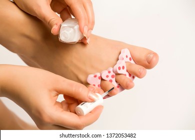 Woman Applying A Nail Polish On Her Toes