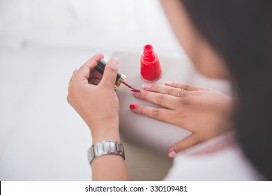 Woman Applying Nail Polish On Her Nail Carefully