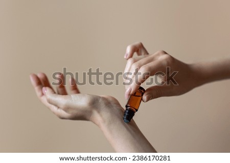 Woman applying natural rollerball aroma oil on her wrist close up	