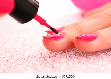 Woman Applying Pink Nail Polish