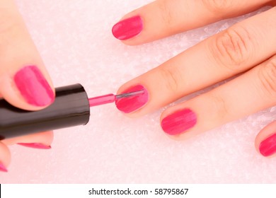 Woman Applying Pink Nail Polish