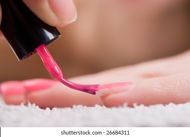 Woman Applying Red Nail Polish