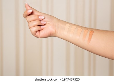 Woman applying shades from light to dark of a liquid makeup foundation on hand. Closeup shot - Shutterstock ID 1947489520