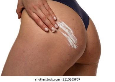 woman applying stretch cosmetic product on her bottom on a white background