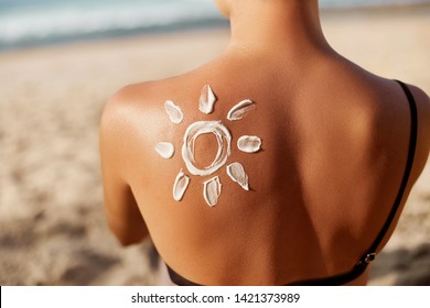 Woman Applying Sun Cream on Tanned  Shoulder In Form Of The Sun. Sun Protection.Sun Cream. Skin and Body Care. Girl Using Sunscreen to Skin. Female Holding Suntan Lotion and Moisturizing Sunblock. - Shutterstock ID 1421373989