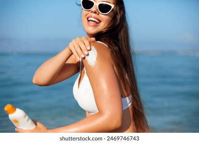 Woman applying sunscreen creme on tanned shoulder. Skincare. Body Sun protection suncream. Gir applying moisturizing sunscreen lotion on back. - Powered by Shutterstock