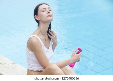 Woman applying sunscreen spray, hair care protection during summer vacation