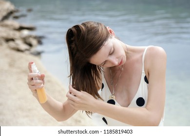 Woman Applying Sunscreen Spray On The Beach, Hair Care Protection Concept