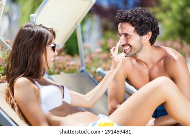 Woman Applying Tan Screen On Her Boyfriend's Nose