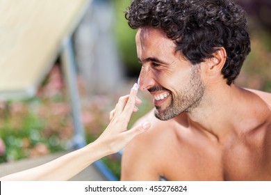 Woman Applying Tan Screen On Her Boyfriend's Nose