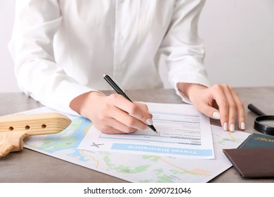 Woman Applying Travel Insurance Form In Office