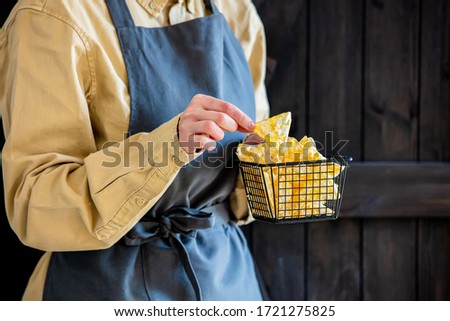 woman in an apron holds healthy vegan chips