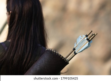 Woman Archer Standing With Her Back With Quiver For Arrows On Blurred Background