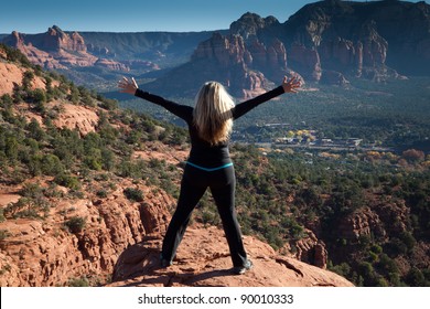 Woman With Arms Wide Open On A Vista In Sedona Over Looking The Red Rock Canyon