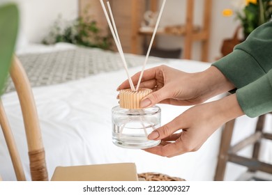 Woman With Aroma Reed Diffuser At Home