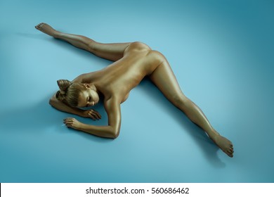 Woman art nude portrait with gold skin shot from above
