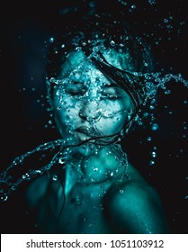 Woman art portrait and splash water in face. beautiful female model on black background. soft focus