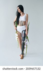 Woman With Artificial Leg Holding Bouquet Of Flowers At Her Hands And Posing