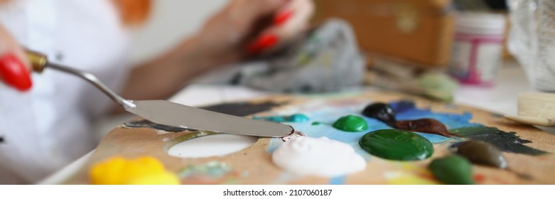 Woman Artist Evens Paint With A Spatula On A Wooden Palette. Hands With Manicure Pick Up Paint For Painting With A Spatula