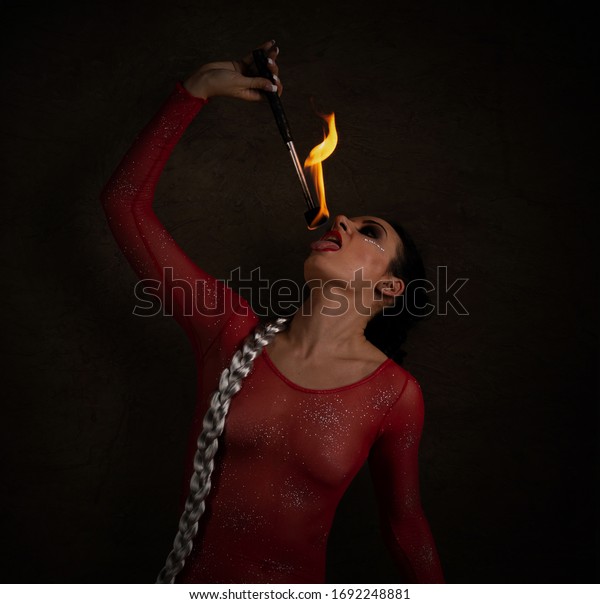 woman artist make fire\
eating show
