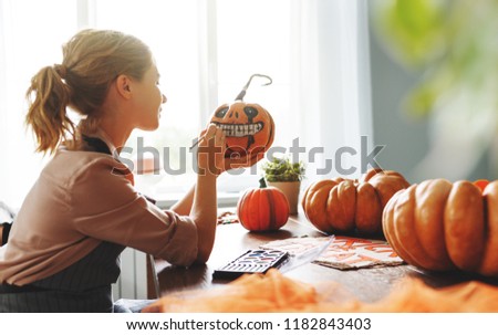 a woman artist prepares for halloween and paints pumpkins