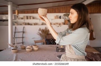 . woman artist sculpts from wet clay in studio. ceramist makes handicrafts from ceramics. female industriousness concept. copy space.