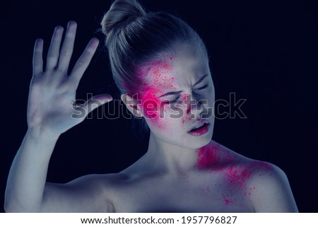 Woman with artistic makeup on dark background. Showing STOP emotion.