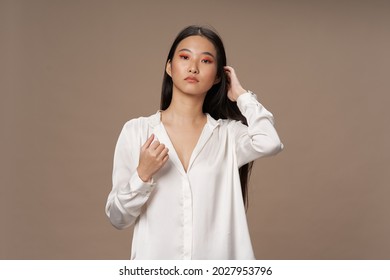 woman of asian appearance bright makeup luxury beige background