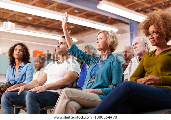 Woman Asking Question At Neighborhood Meeting In
Community Center
