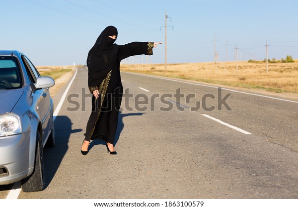 Woman asks for help on an\
empty road.