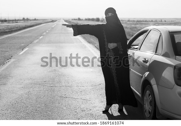 Woman asks for help on the road, muslim woman\
in traditional dress. Black and\
white