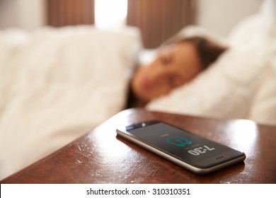 Woman Asleep In Bed Woken By Alarm On Mobile Phone