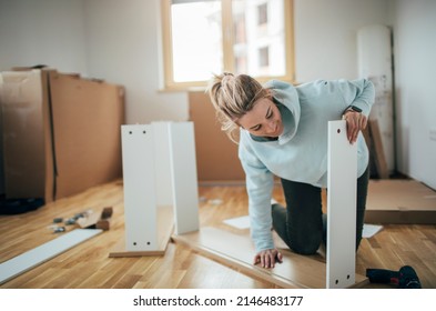 Woman Assembling Furniture At Home 