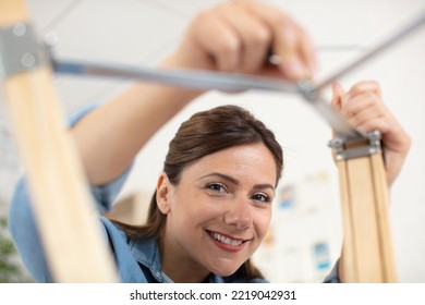 Woman Assembling Furniture In New House